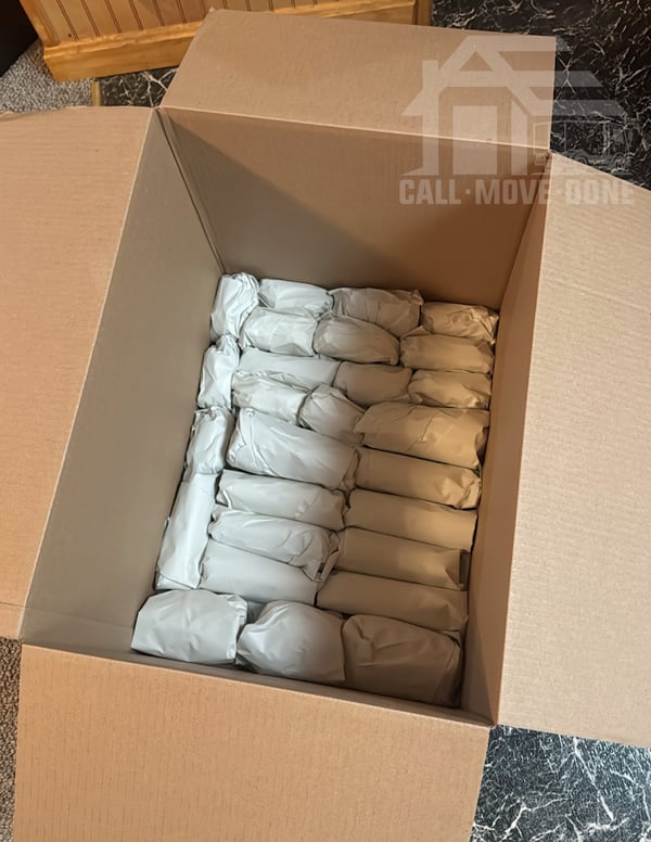 Dish box packed with individually wrapped glassware standing on edge