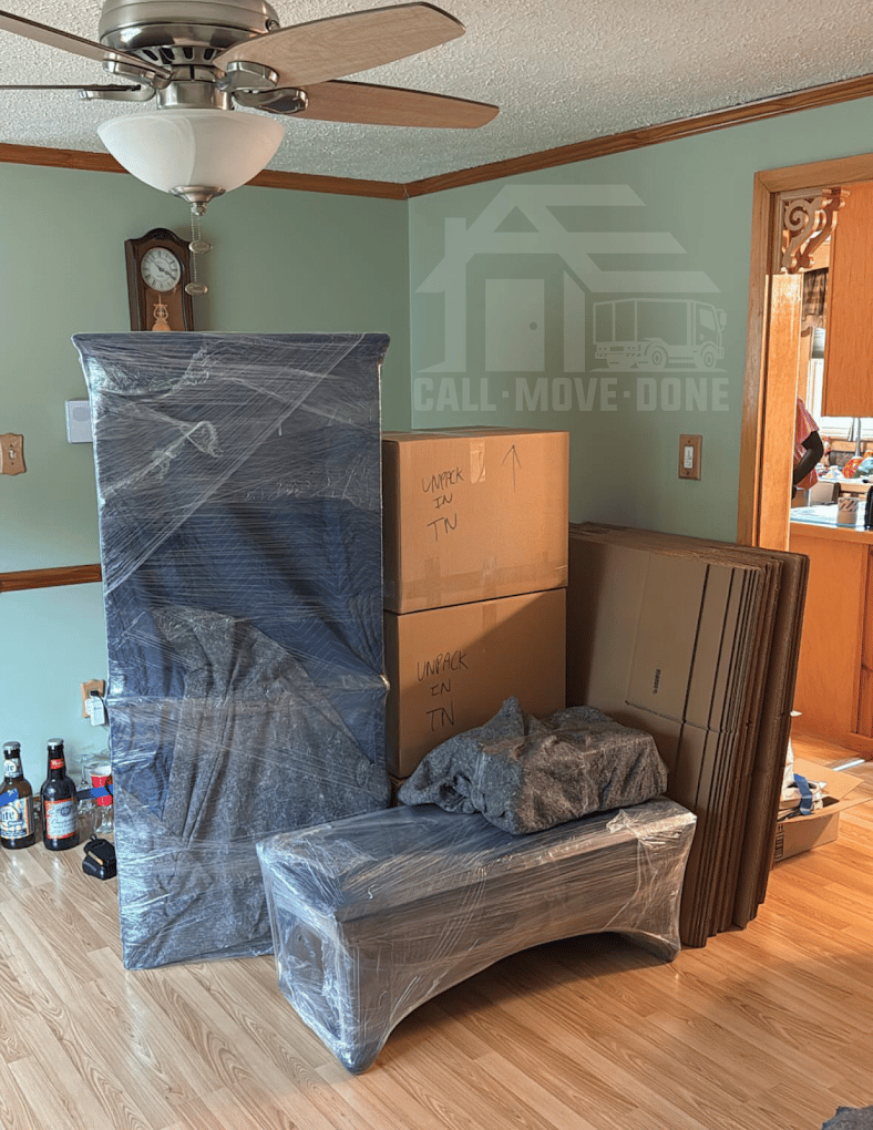 Wrapped furniture and labeled boxes staged in a living room