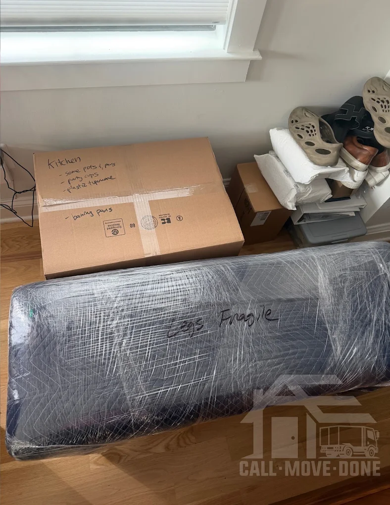 Hand-labeled kitchen box next to a wrapped bench marked legs fragile