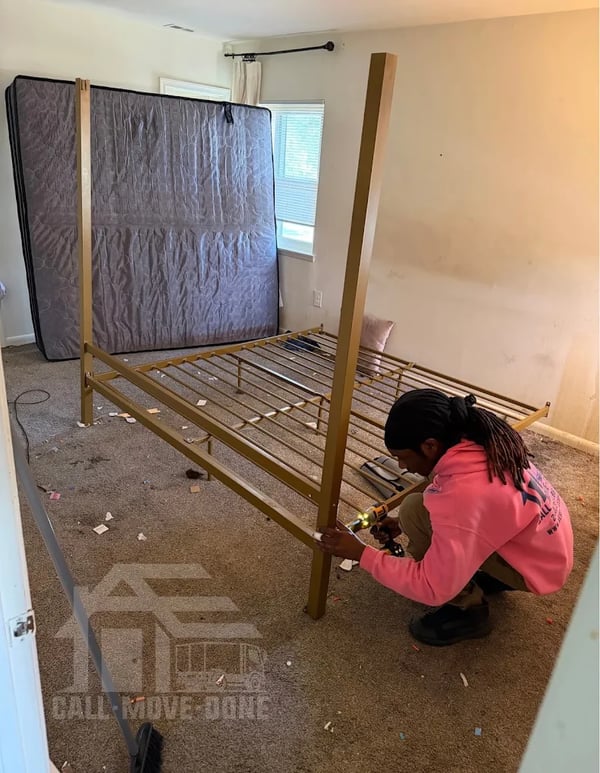 AE Services mover assembling a gold canopy bed frame