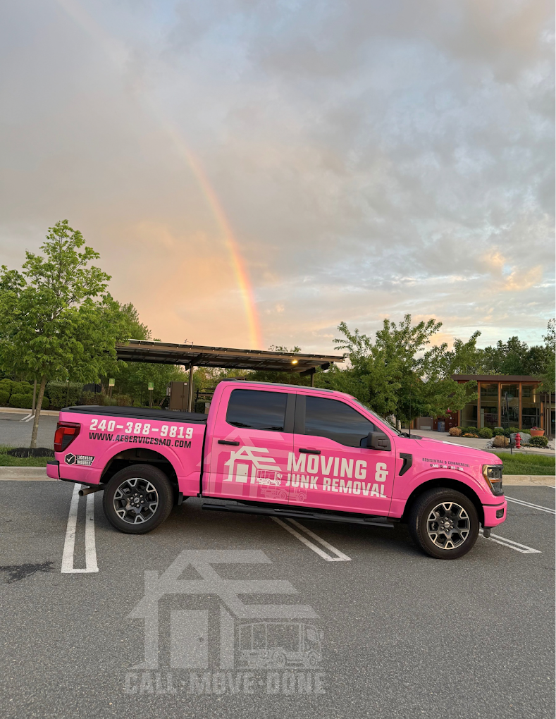 The pink AE Services pickup truck parked under a rainbow at sunset