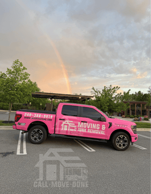 The pink AE Services truck under a rainbow