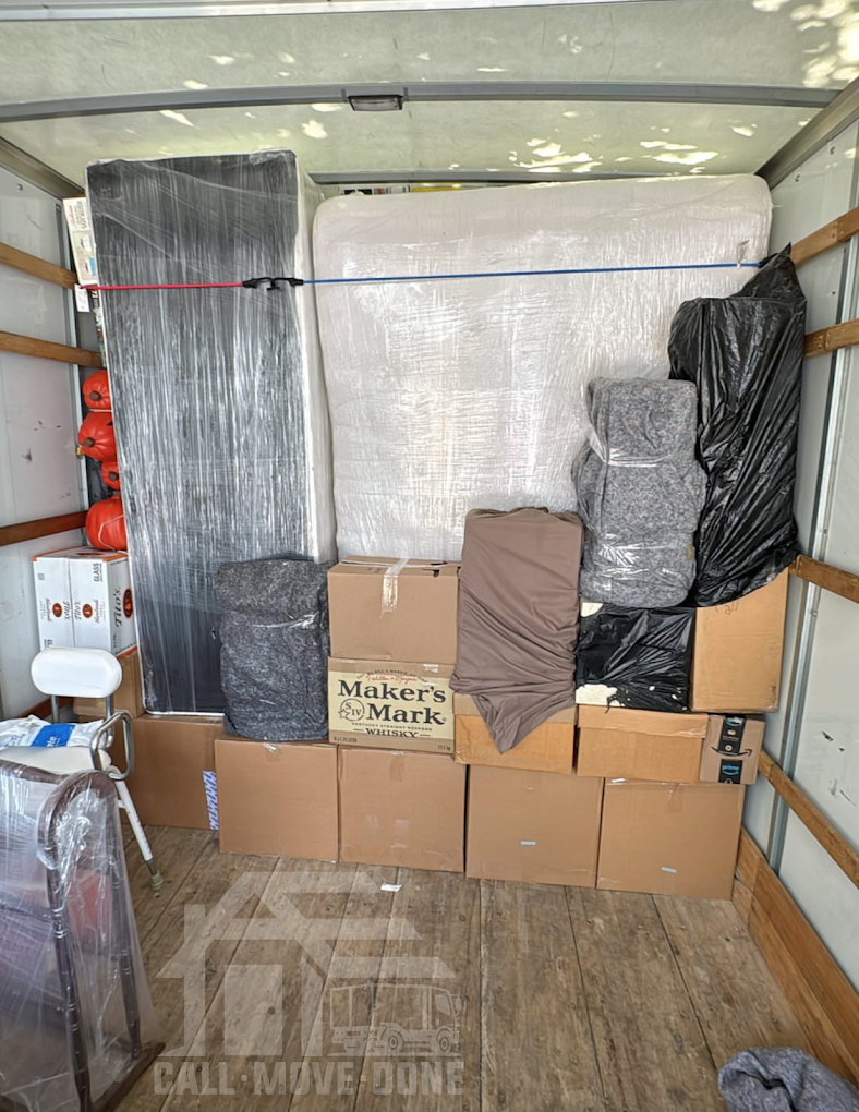 Box truck loaded in strapped tiers with mattresses standing upright